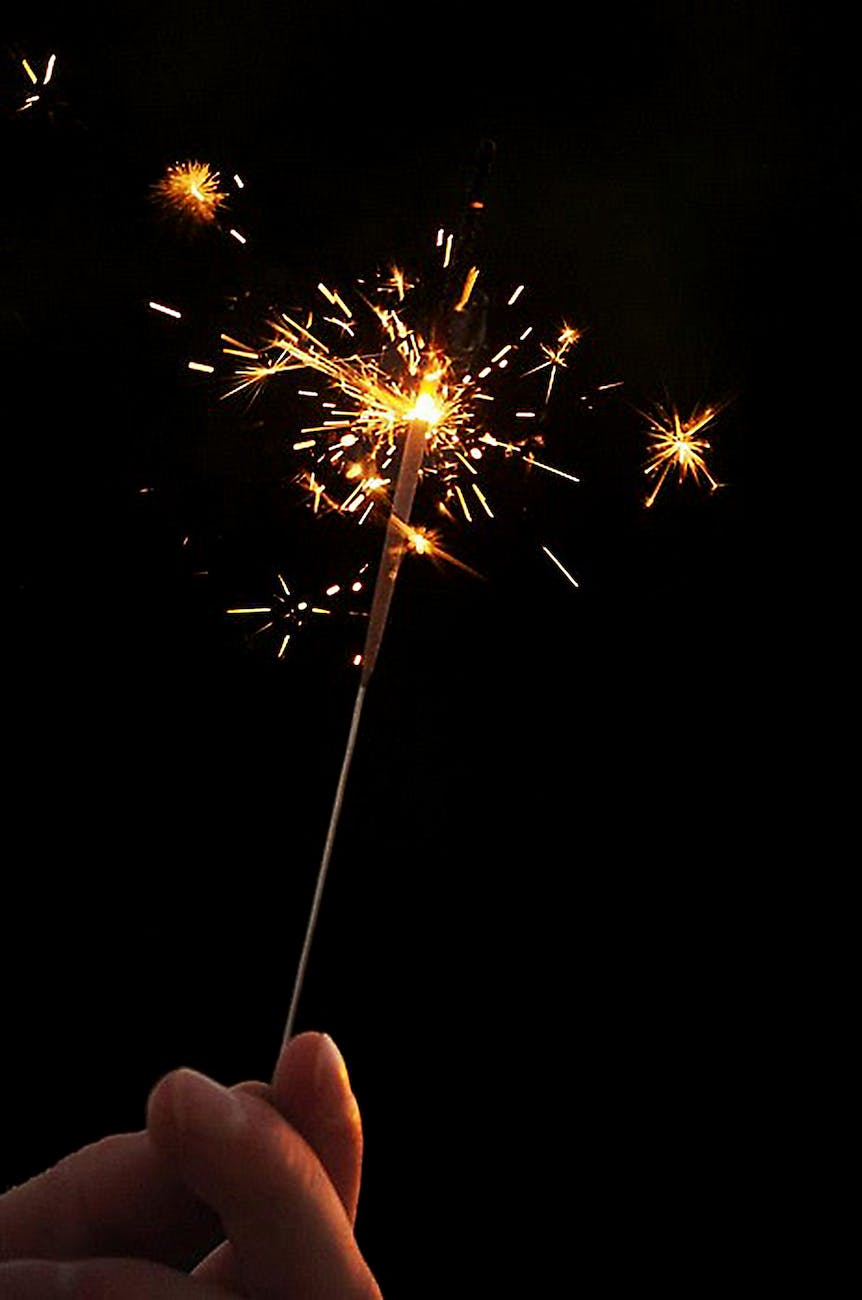 timelapse photography of person holding sparkler